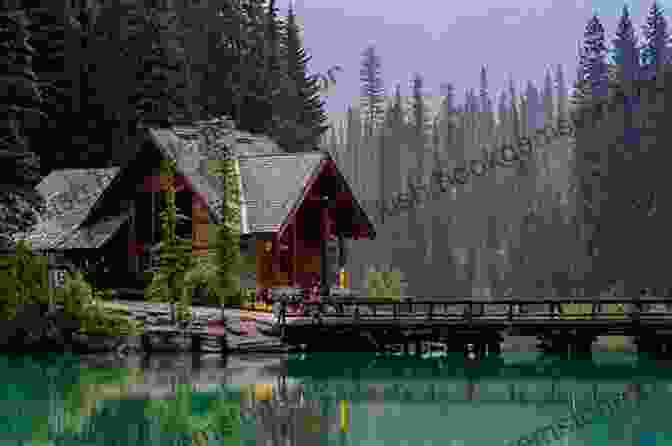 Emerald Lake With A Wooden Bridge Leading To A Small Island, Surrounded By Towering Mountain Peaks And Lush Vegetation The Canadian Rockies: Yoho Kootenay National Parks